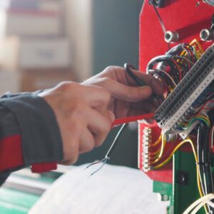 Electrician's hands installing energy system on machinery industry, close up