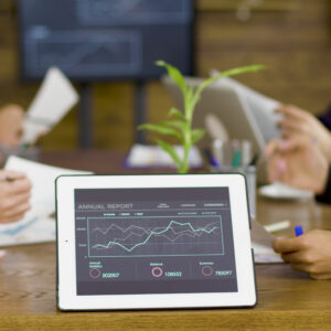 Tablet PC with graphs in a conference room. Team brainstorm.