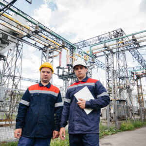 Two specialist electrical substation engineers inspect modern high-voltage equipment. Energy. Industry